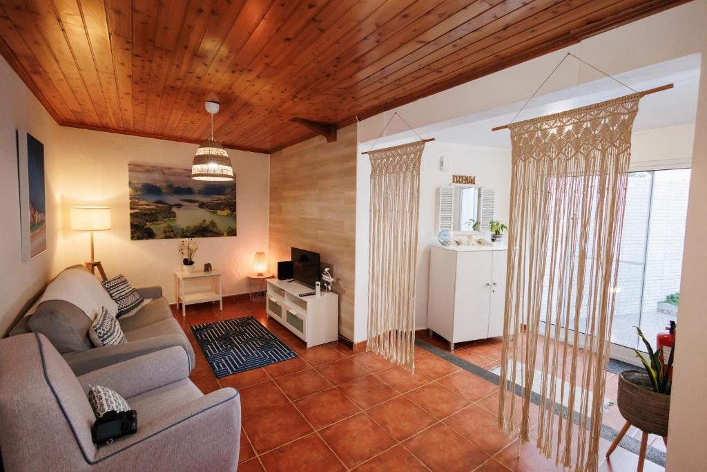 a living room with a couch and a tv at Cozy Beach House in Ribeira Grande