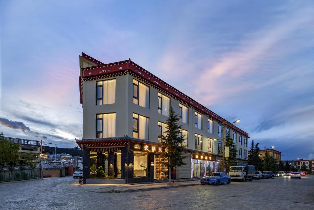 ein großes Gebäude mit einem davor geparkten Auto in der Unterkunft Shangri La Anyu Garden Resort Hotel in Shangri-La