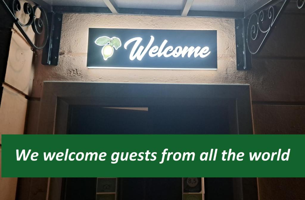 ein Willkommensschild an einer Wand mit einem Begrüßungsgast aus der ganzen Welt in der Unterkunft St. John Villa in Rom