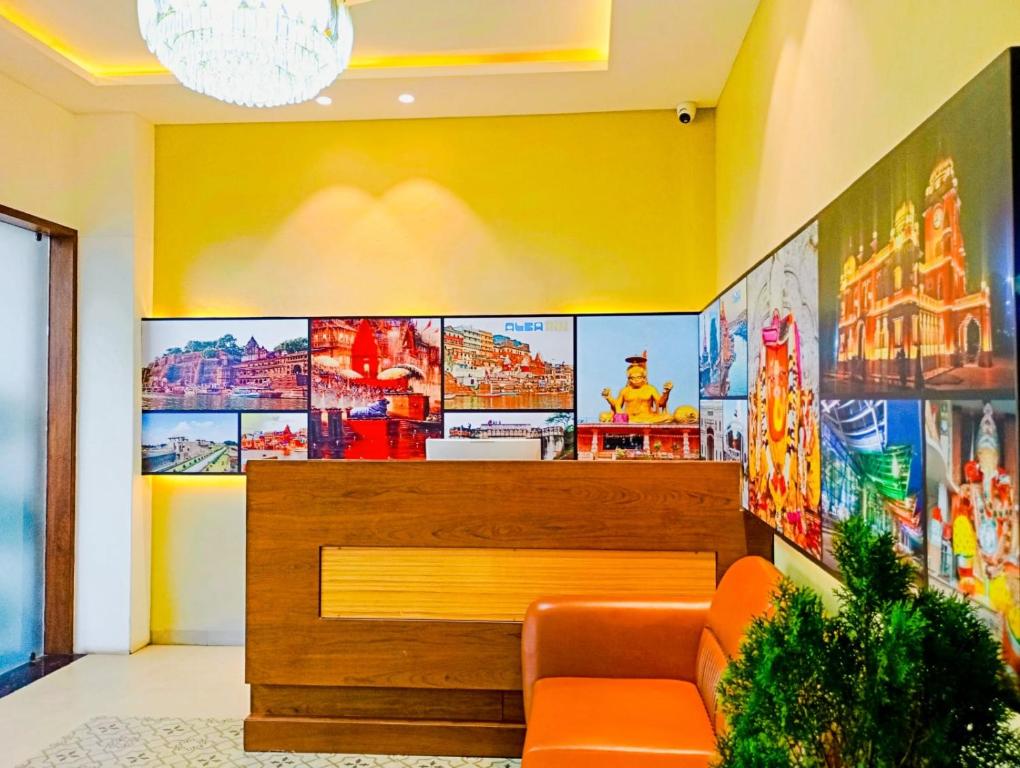 een wachtkamer met een oranje bank en grote schermen bij Pravasa Stay Near Luv Kush Square in Indore