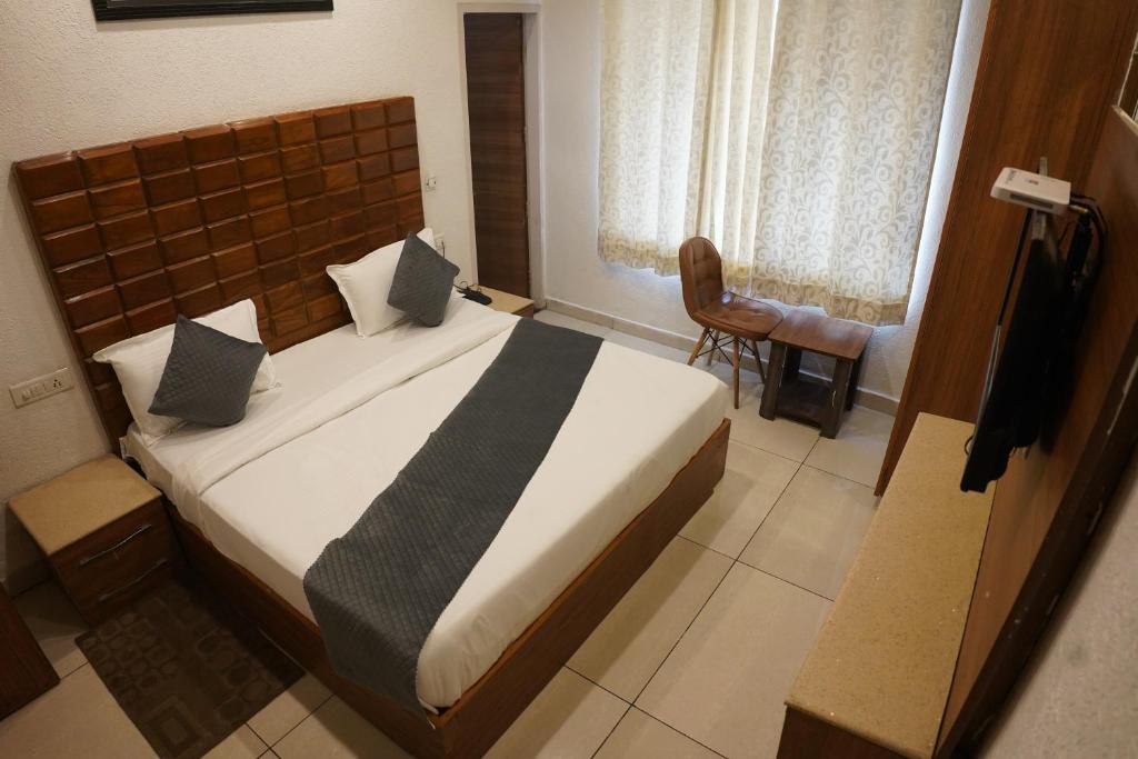 Un dormitorio con una cama grande en una habitación. en Hotel Sharrytel, en Zirakpur