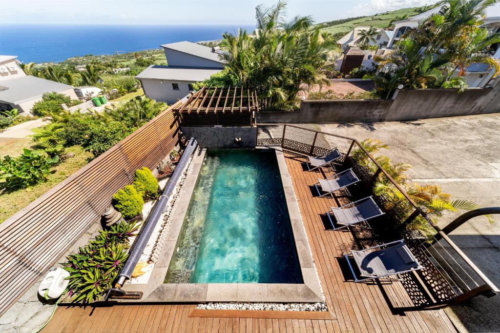 an overhead view of a swimming pool with chairs and the ocean at L'HORIZON F2 ti cocooon in Petite Île