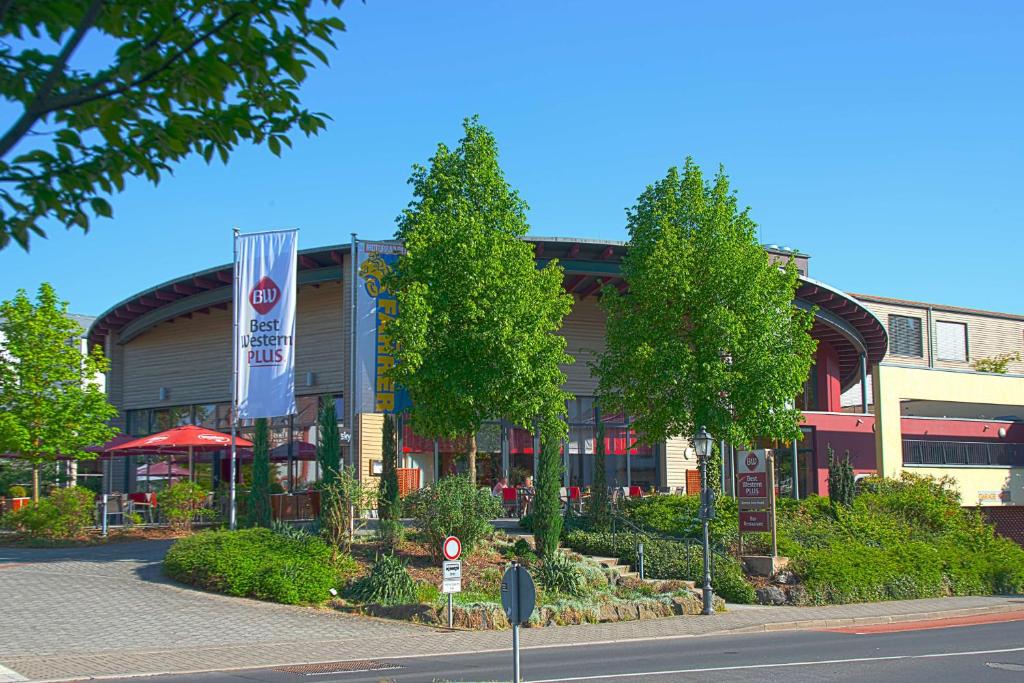 a building with a restaurant in front of a street at Best Western Plus Konrad Zuse Hotel in Hünfeld