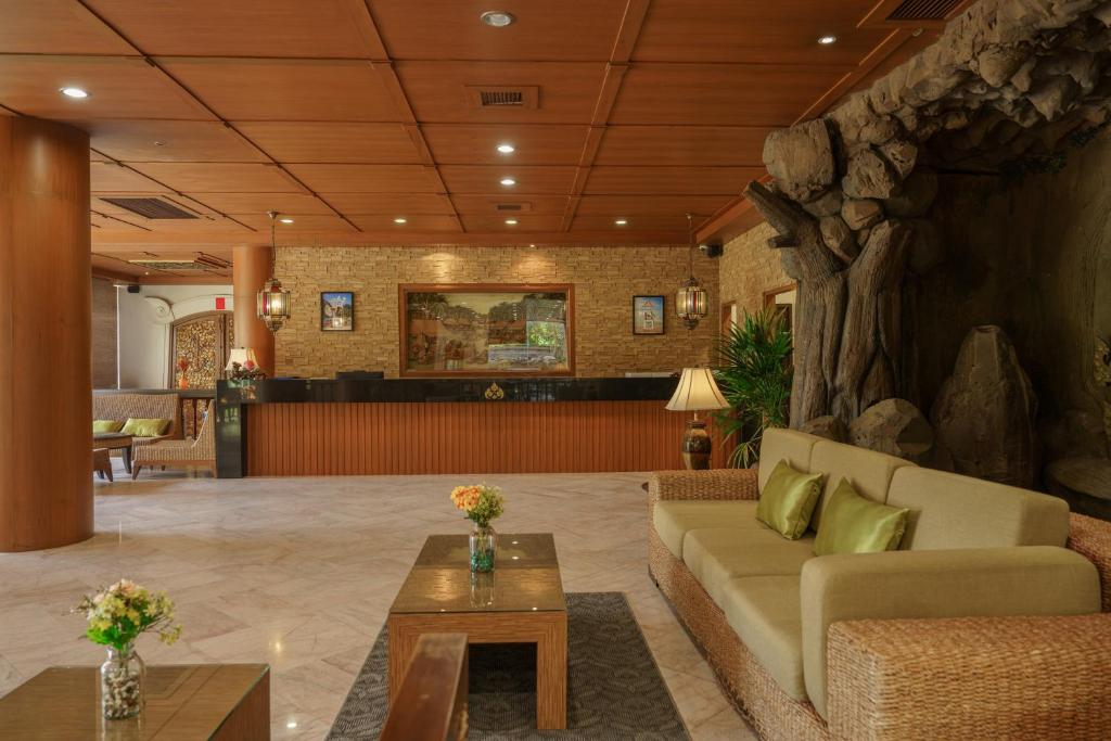 A spacious lobby lounge with reception, sofas, coffee tables and dramatic rock-style decor.