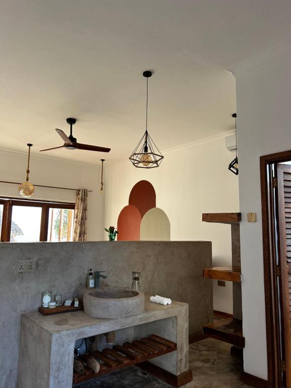 ein Bad mit einem Waschbecken und einem Deckenventilator in der Unterkunft Zanzi Soul Luxury Boutique Hotel in Jambiani