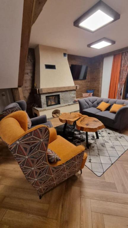 a living room with couches and tables and a fireplace at Willa Skalny Potok 605-077-100 in Zakopane