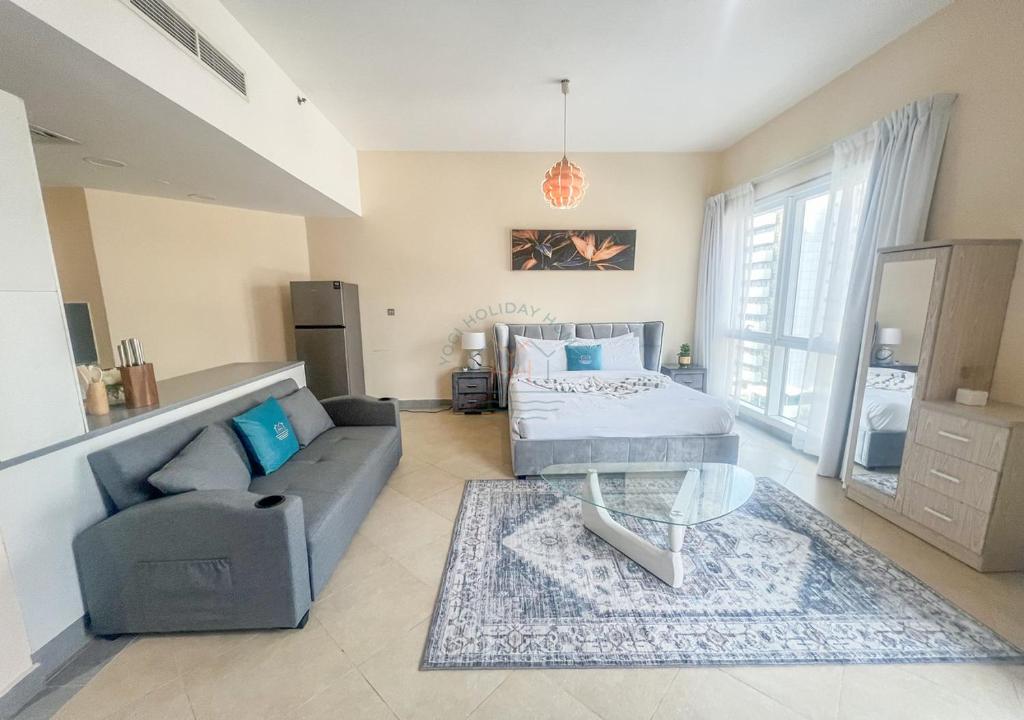 una sala de estar con un sofá y una mesa en Snug Studio With City Views, Perfect For Couples, en Dubái