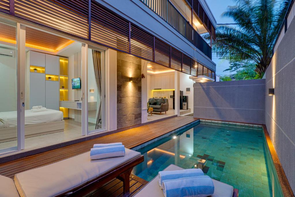 a house with a swimming pool and a bedroom at Villa Moana - Nusa Dua in Nusa Dua