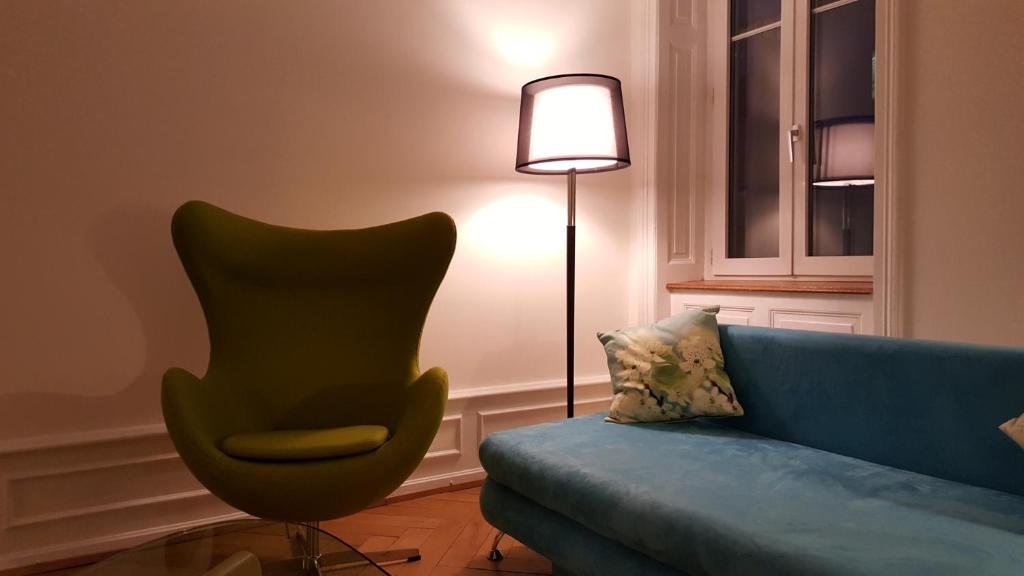 a living room with a blue couch and a lamp at Basel Charme Apartments in Basel