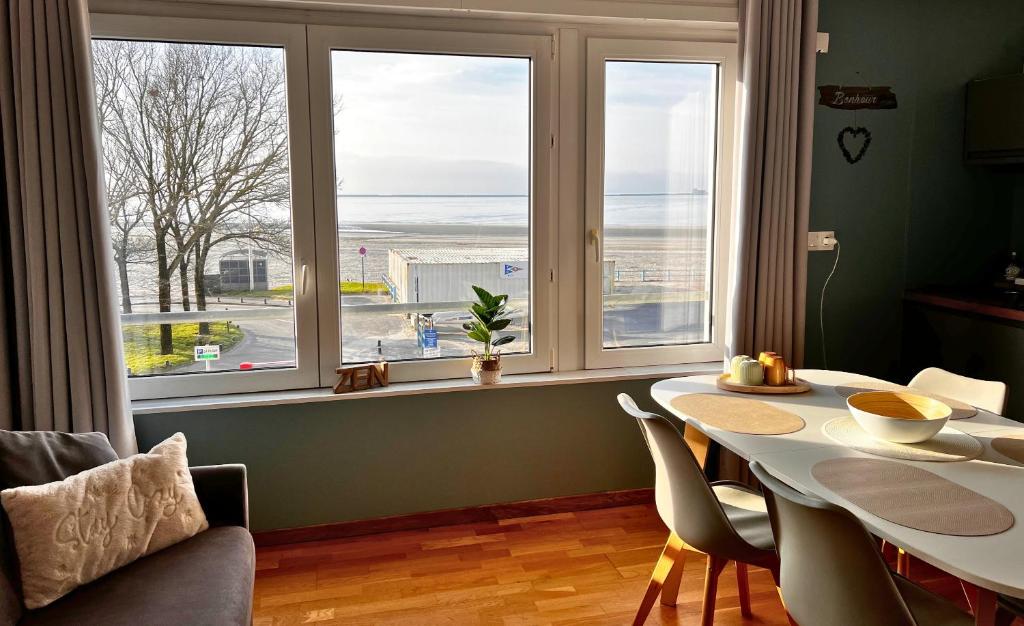 une salle à manger avec une table et une grande fenêtre dans l'établissement La Vue Sur Mer - Appart avec place de parking, à Boulogne-sur-Mer