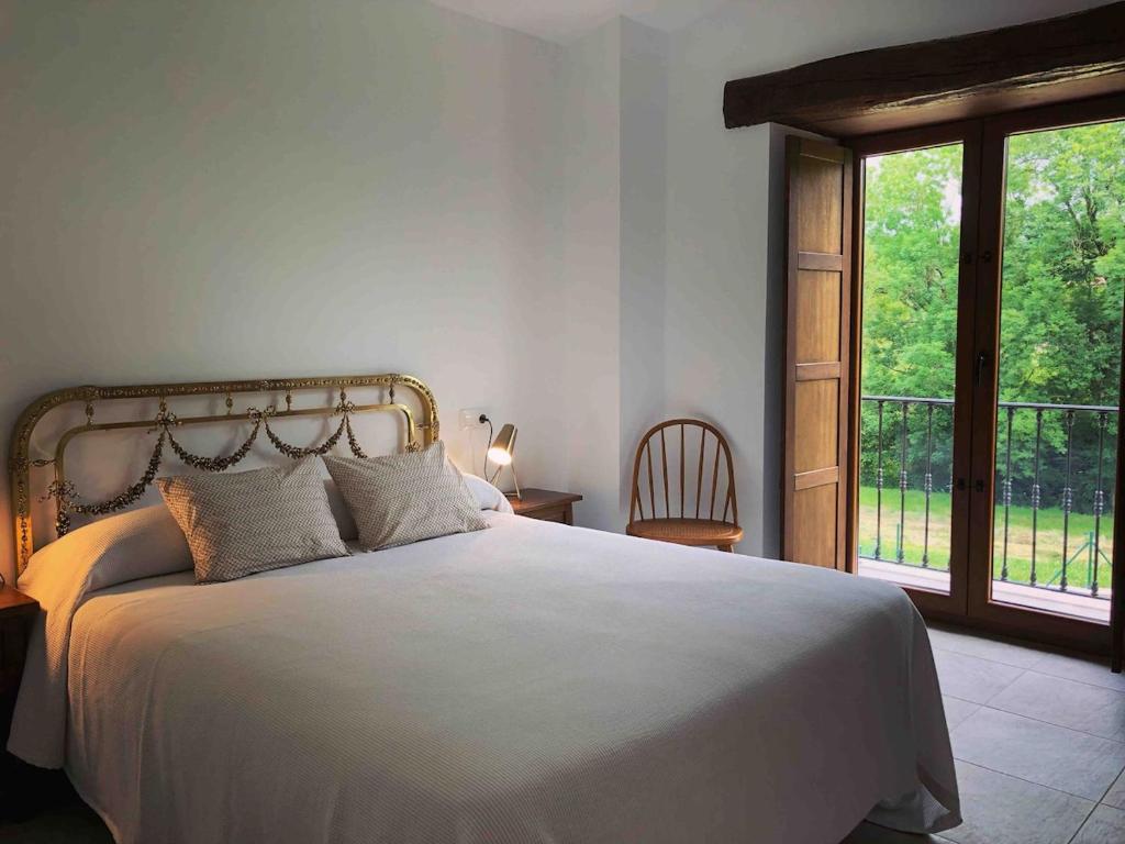 a bedroom with a large bed and a window at El Molino de La Canal in Vega