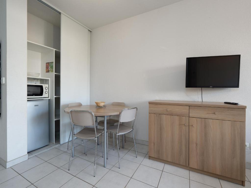 une cuisine avec une table et deux chaises ainsi qu'une télévision dans l'établissement Cap Camargue B N 26 - 2P4, au Grau-du-Roi