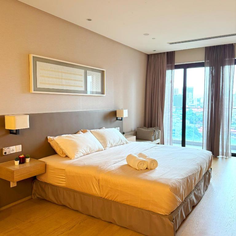 Un dormitorio con una cama grande con dos toallas encima. en 188 Suites KLCC Hotel with bathtub in KL, en Kuala Lumpur