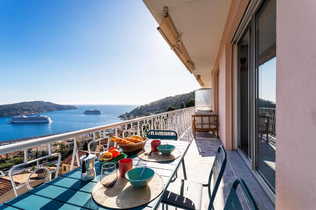d'un balcon avec des tables et des chaises offrant une vue sur l'océan. dans l'établissement LE SAINT ESTEVE AP4435 By Riviera Holiday Homes, à Villefranche-sur-Mer