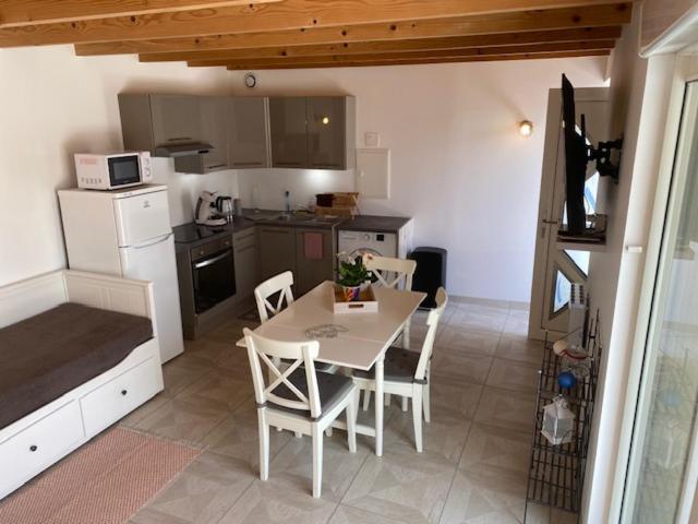 une cuisine avec une table et des chaises dans une pièce dans l'établissement les gites du corsen, à Plouarzel