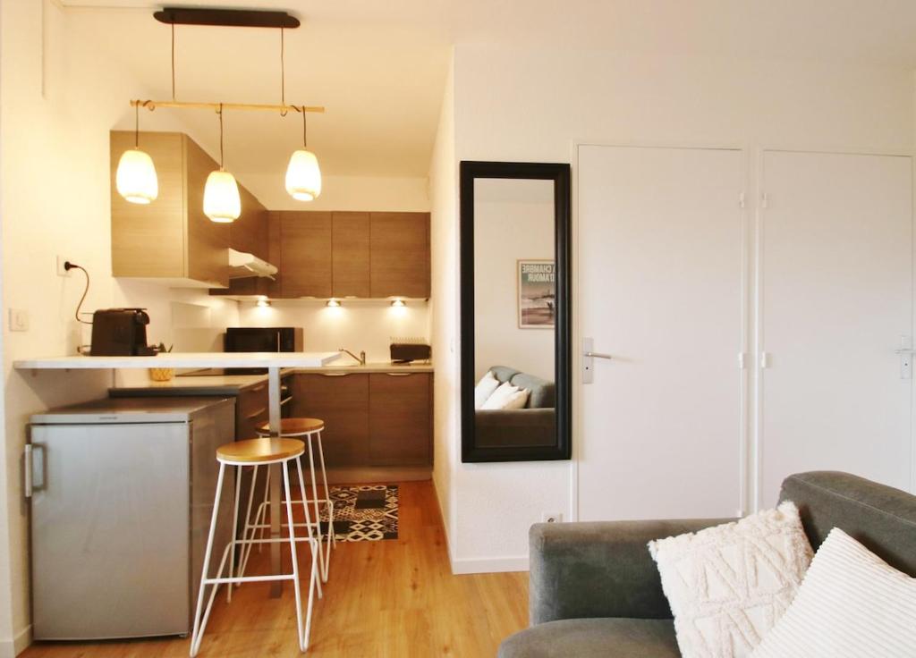 un salon avec un canapé et une cuisine dans l'établissement T2 avec piscine à Anglet Golf de Biarritz, à Anglet