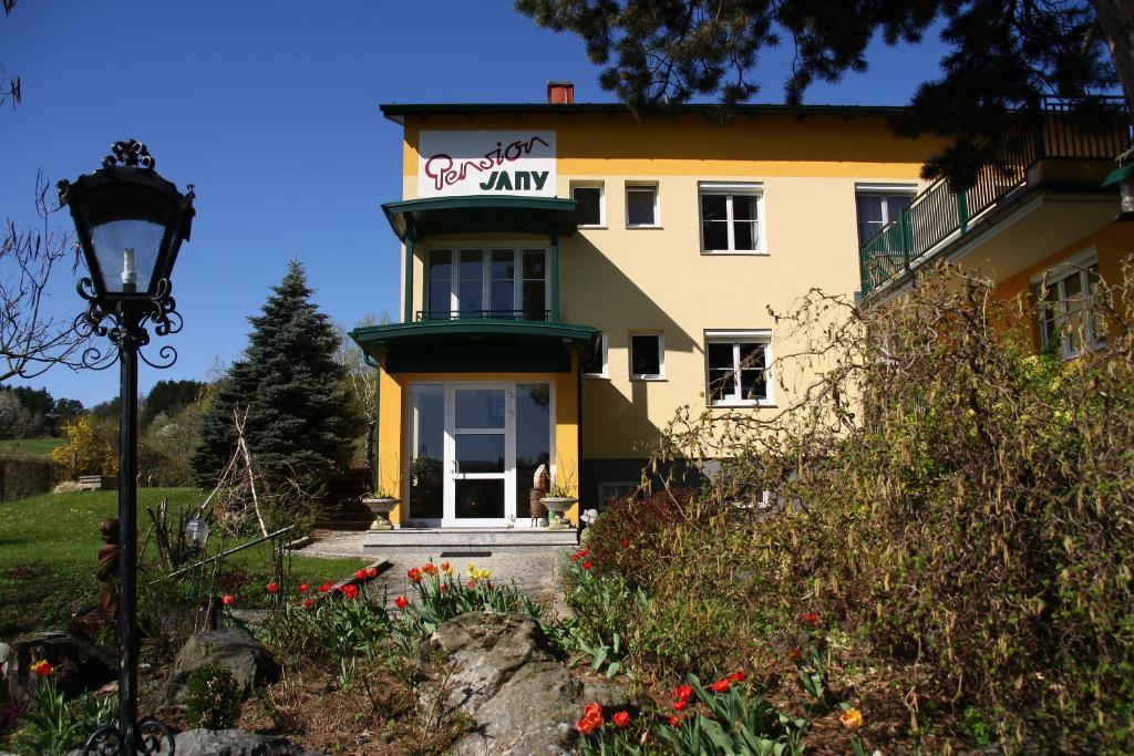 ein großes gelbes Gebäude mit einem Schild drauf in der Unterkunft Landhaus Pension Jany in Bad Tatzmannsdorf