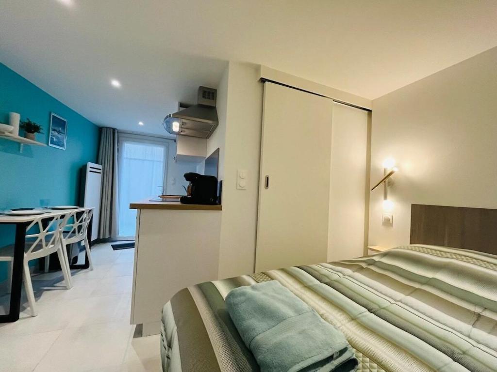 une chambre avec un lit et une cuisine avec une table dans l'établissement Le Lys Bleu, à Angers