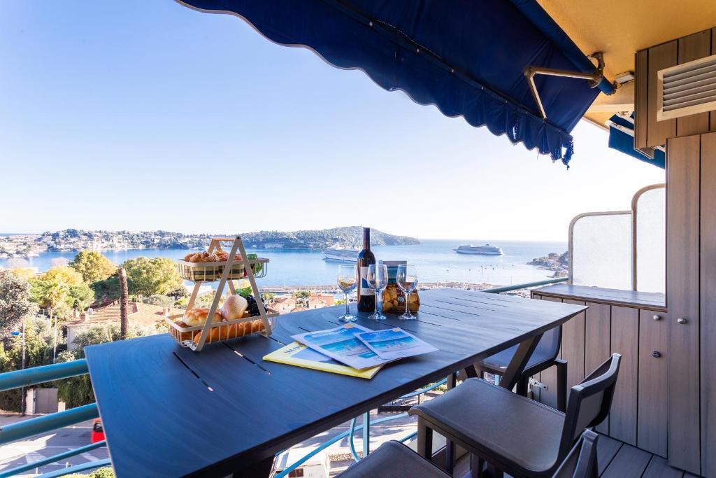 - une table sur un balcon avec vue sur l'océan dans l'établissement Esterel AP4431 By Riviera Holiday Homes, à Villefranche-sur-Mer
