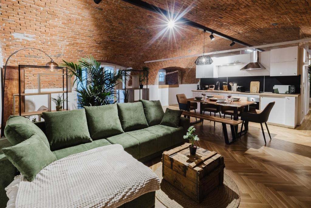 un soggiorno con un divano verde e un tavolo di Ziegelloft Appartements - Altstadtnah und direkt an der Ilz a Passavia