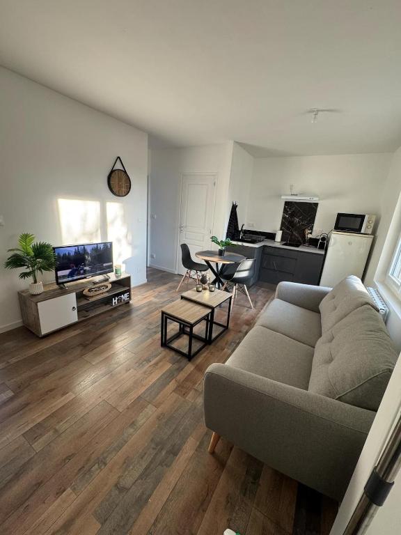 - un salon avec un canapé, une table et un piano dans l'établissement Le 77! Apartment type 2, à Châlons-en-Champagne
