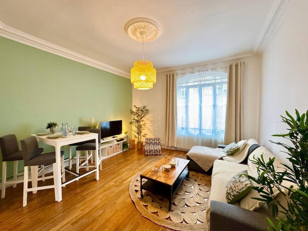 un salon avec un canapé et une table dans l'établissement La suite Jade de Reims - Cathédrale, à Reims
