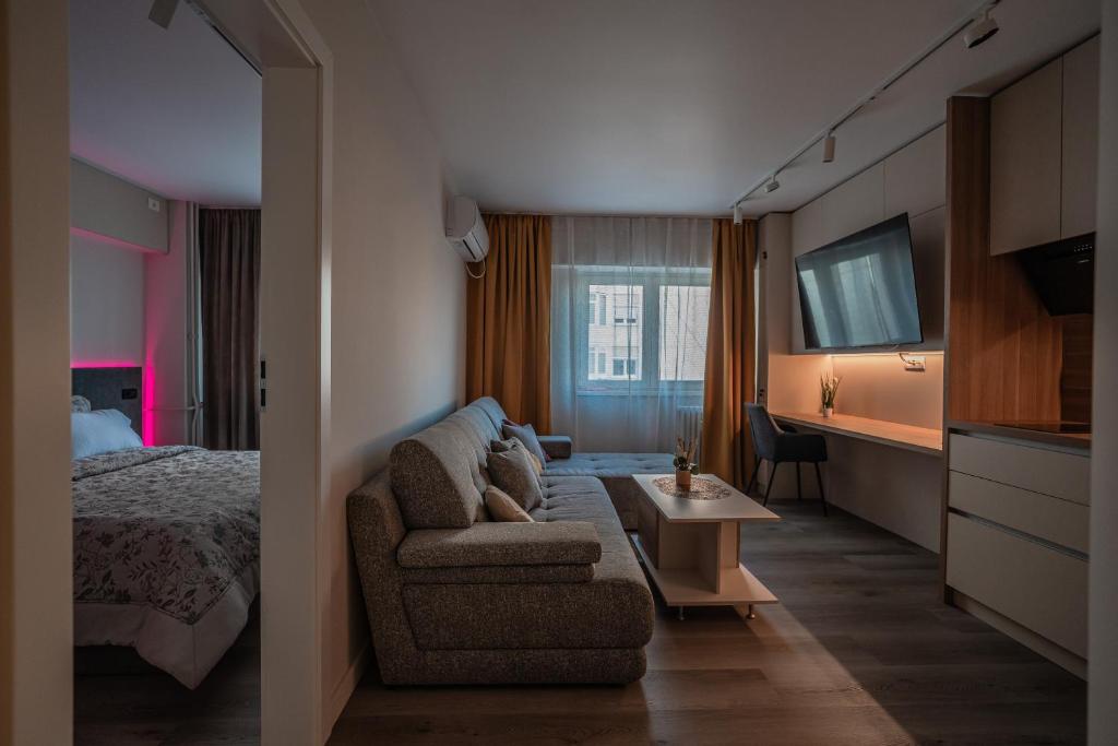 a hotel room with a couch and a bed at Lotus 1 in Ploieşti