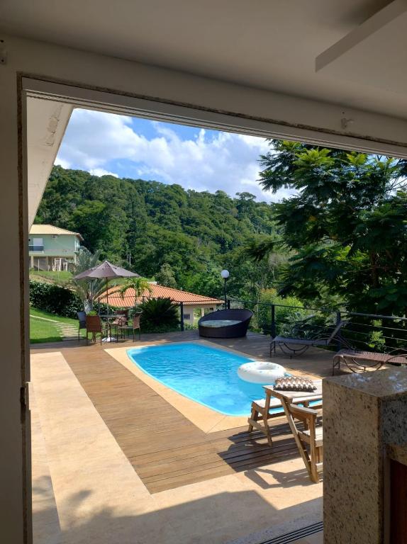 a view of a swimming pool through a sliding glass door at Descanso na Serra in Areal