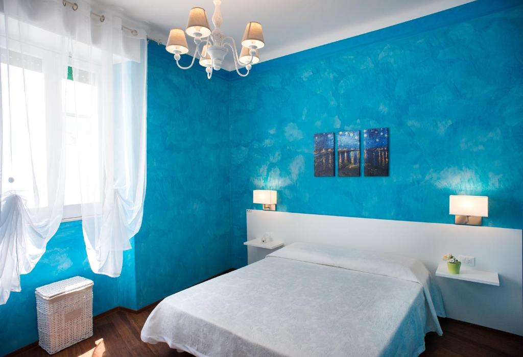 niebieska sypialnia z łóżkiem i niebieską ścianą w obiekcie Driade dei Trulli w Alberobello