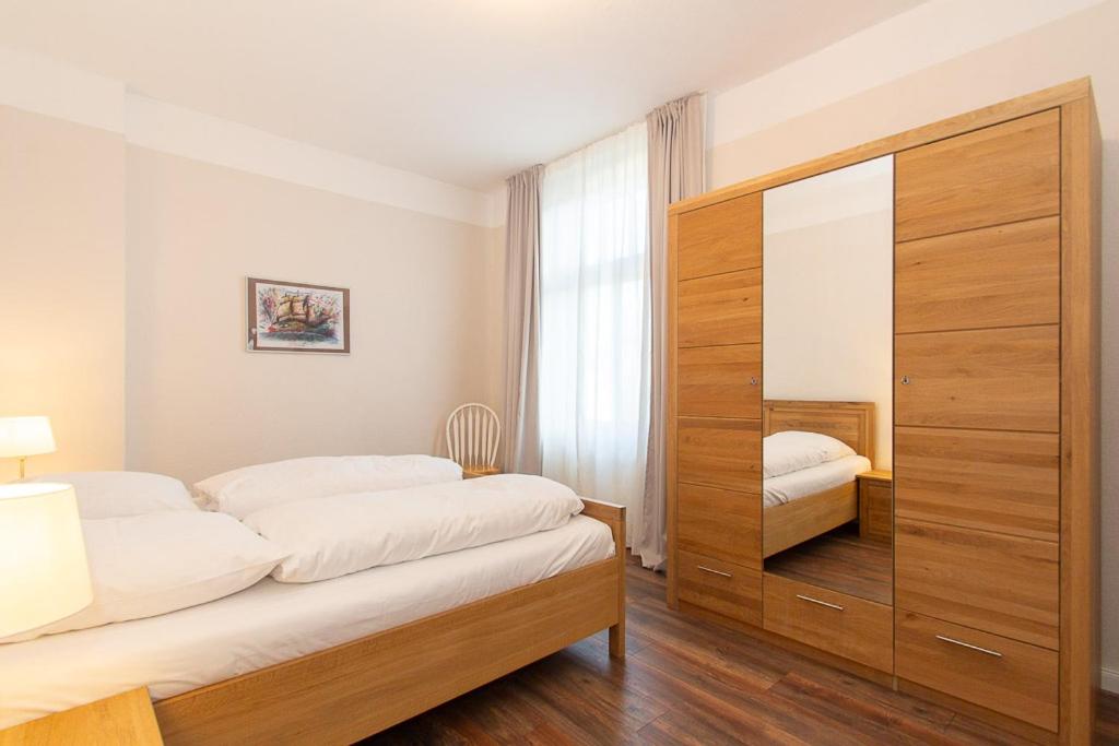 a bedroom with a large wooden cabinet with a mirror at 5 Meereslust in Rostock