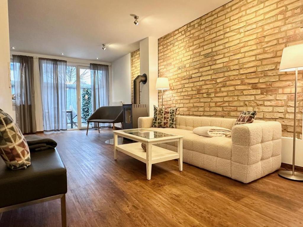 a living room with a couch and a brick wall at Skipperlodge - Versteck am Strom in Warnemünde