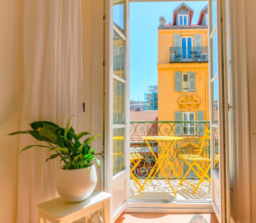 Cette chambre dispose d'une fenêtre et d'un vase avec une plante. dans l'établissement Hyper Centre, balcon, 5min de la plage, AC, à Nice