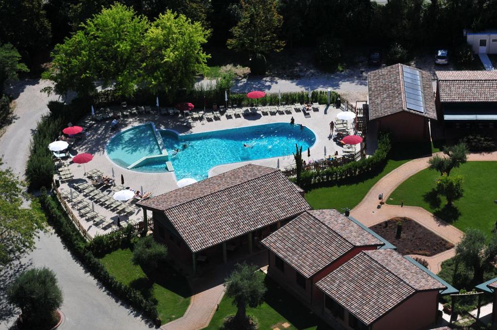 an overhead view of a swimming pool with tables and umbrellas at Due Ponti Village in Cesenatico