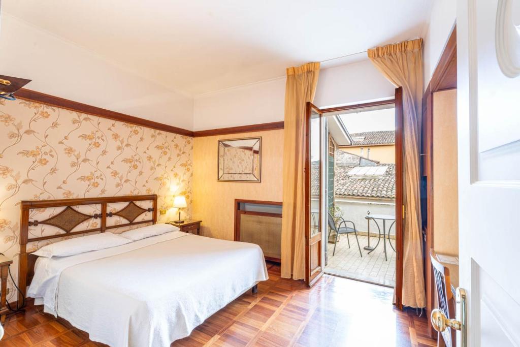 sypialnia z łóżkiem i balkonem w obiekcie Hotel&Ristorante Miramonti Palazzo Storico w mieście Rieti
