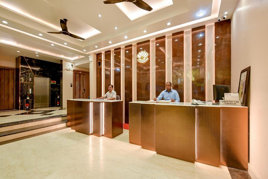 two people sitting at a counter in a lobby at The Pearl Plaza Hotel - Walking Distance From New Delhi Railway Station and Connaught Place in New Delhi