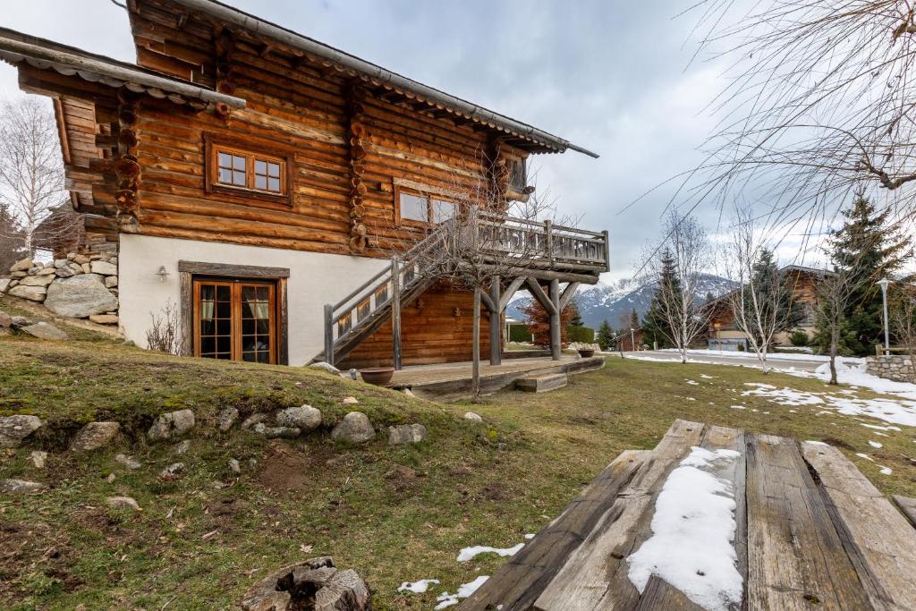 a log house with a deck on the side of it at Chalet des Sonnailles - Montagnes jardin et garage in Bolquere Pyrenees 2000