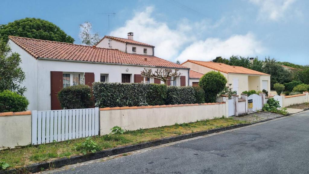 une maison blanche avec une clôture sur le côté d'une rue dans l'établissement Saint Georges de Didonne - MAISON avec jardin clos - PROCHE COMMERCES, à Saint-Georges-de-Didonne