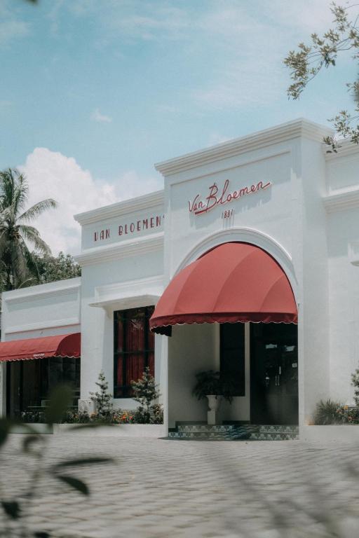 a white building with a red awning at Van Bloemen 1881 Resort in Kembanglimus