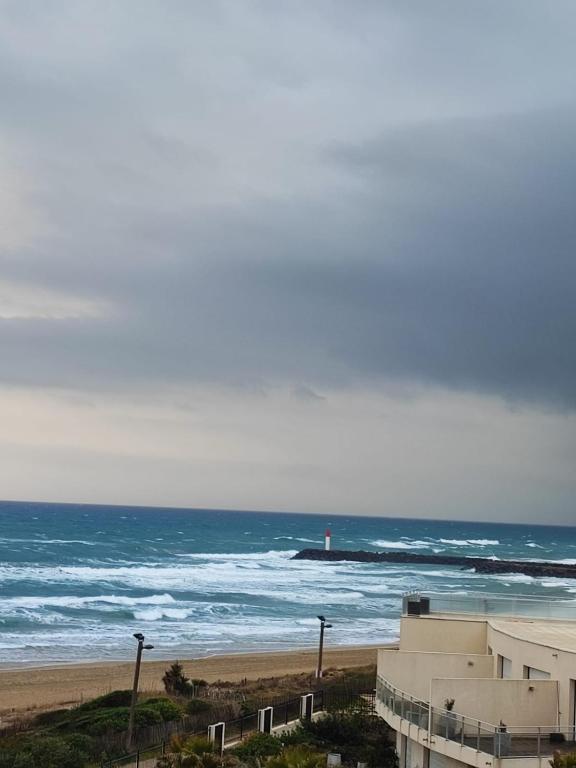 - une vue sur la plage et un phare sur l'océan dans l'établissement Héliopolis Vue mer, au Cap d'Agde