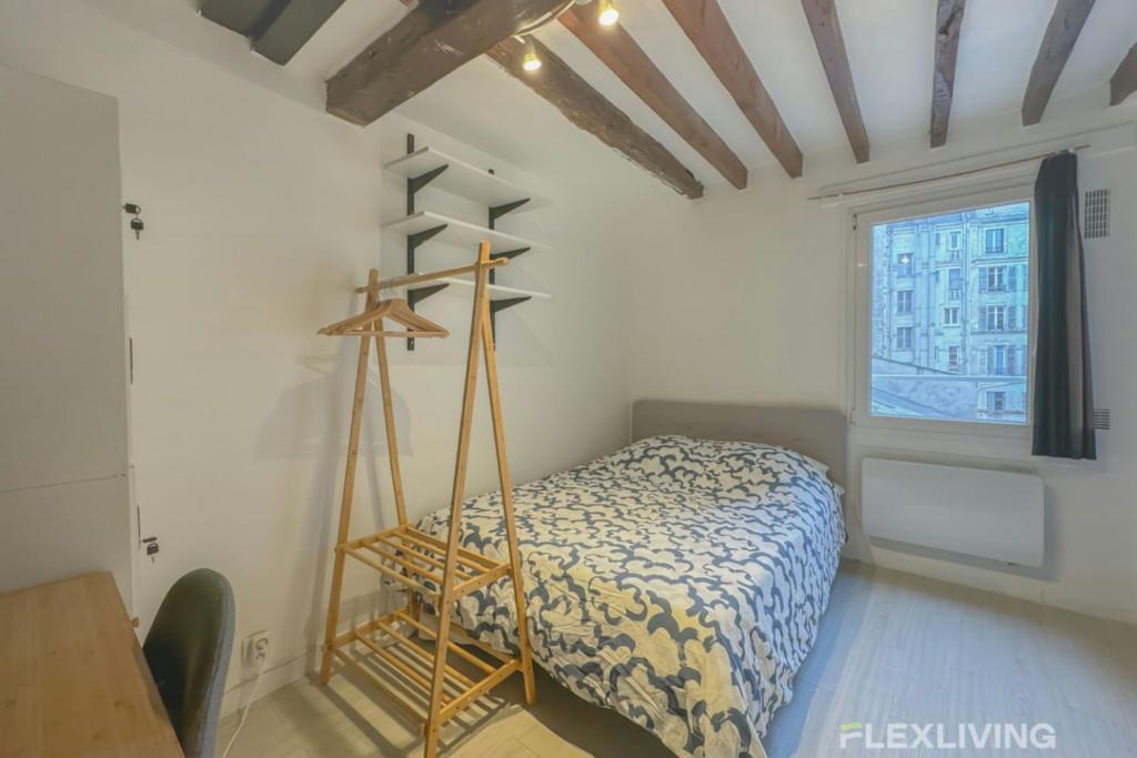 une chambre avec un lit dans une pièce avec une fenêtre dans l'établissement Flexliving - studio - Lacépède, à Paris