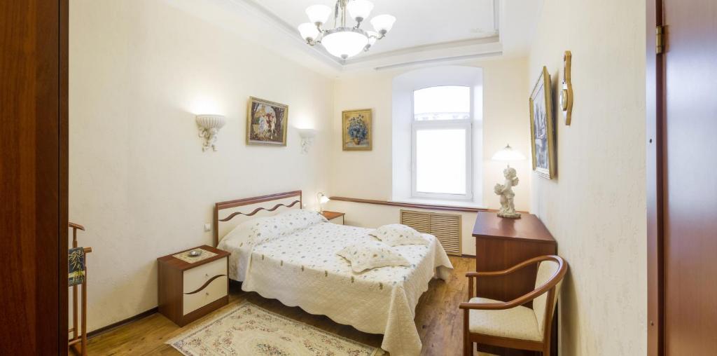 a bedroom with a bed and a window at Gostiniy Dvor on Troitskaya in Samara