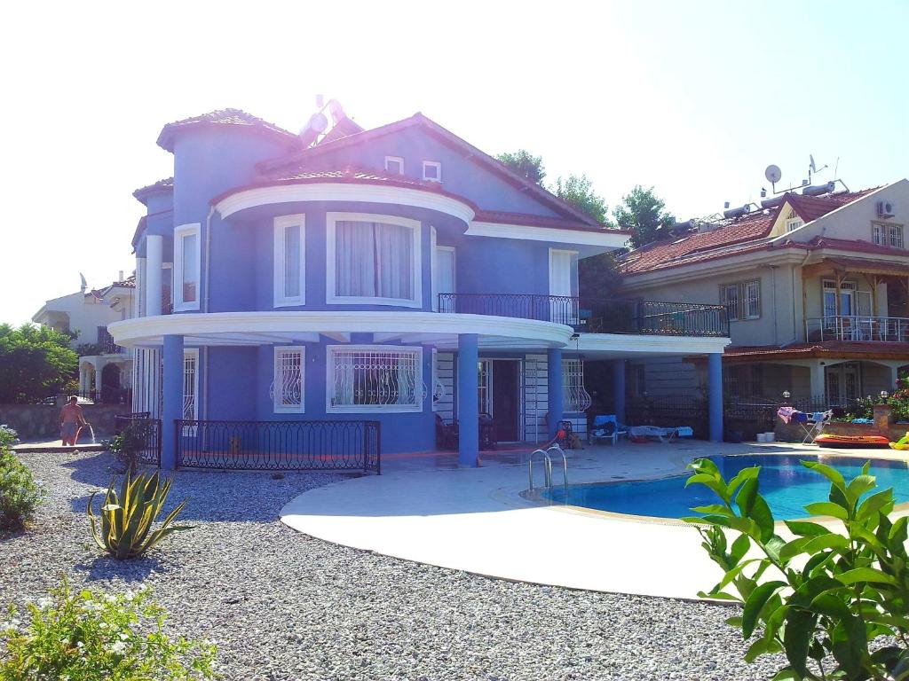 una casa azul con piscina frente a ella en Villa Mavi Çalis, en Fethiye