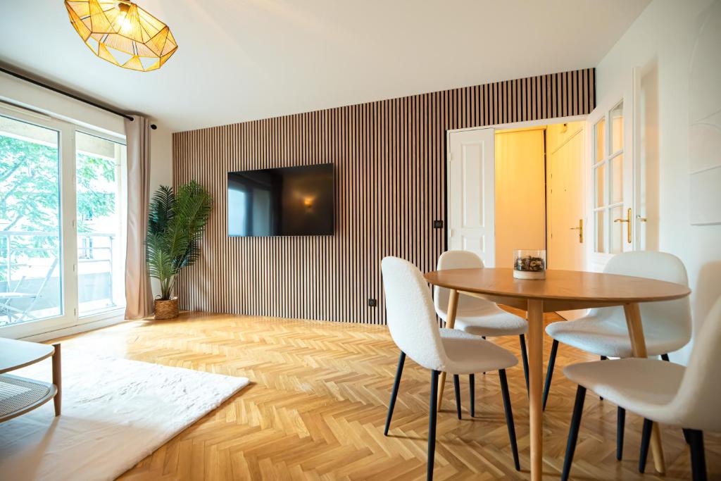 une salle à manger avec une table et des chaises blanches dans l'établissement CIA - Flat with Balcony in East Paris, Buttes Chaumont, à Paris