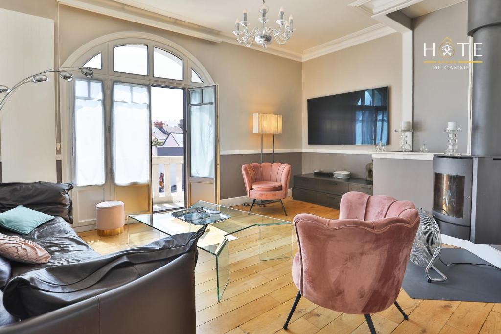 un salon avec un canapé, des chaises et une télévision dans l'établissement Villa luxueuse en bord de mer, à Les Sables-dʼOlonne