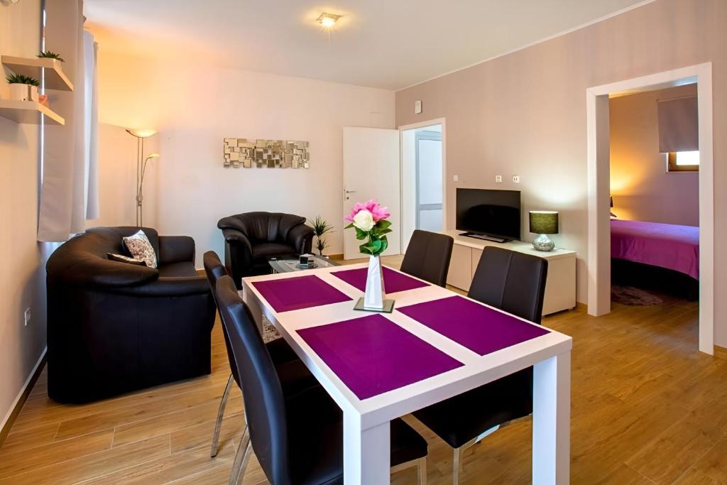ein Wohnzimmer mit einem Tisch und Stühlen sowie ein Zimmer in der Unterkunft Apartman Candy Split with jacuzzi and parking place in Split