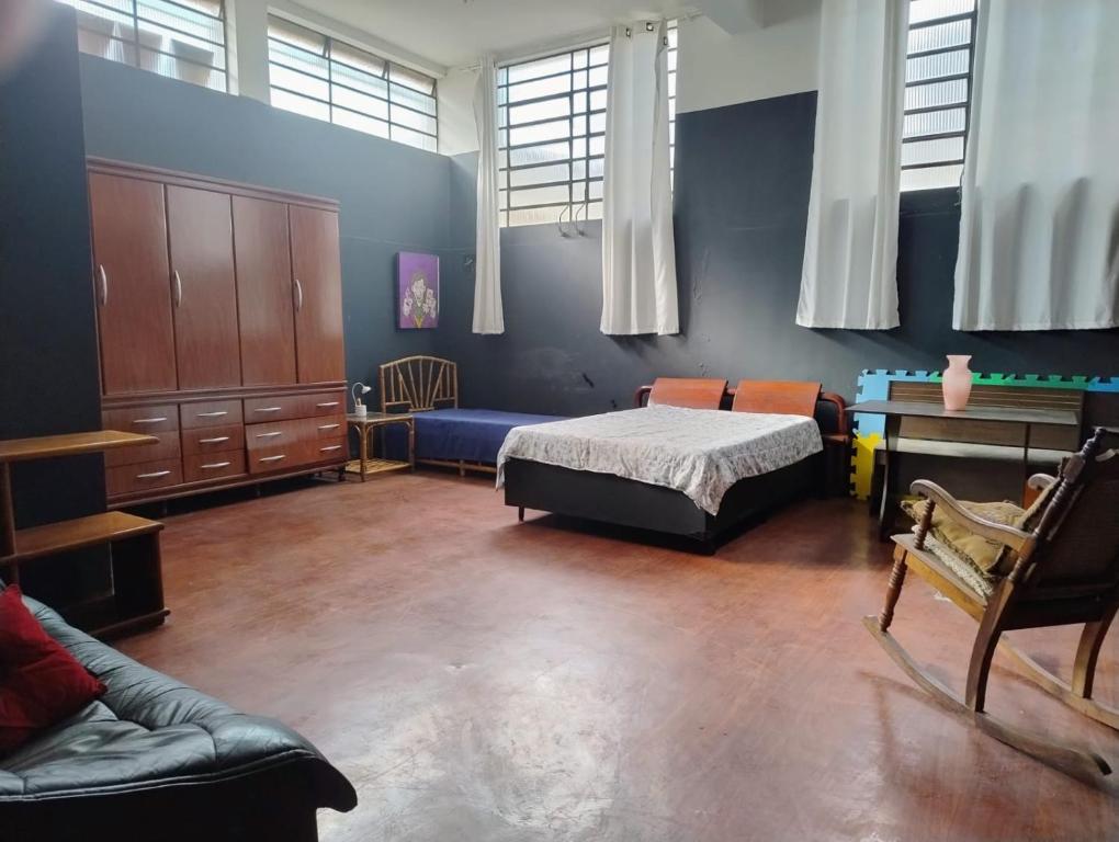 a bedroom with a bed and a desk and a couch at Casa loft Internet 500Mb in Sao Paulo