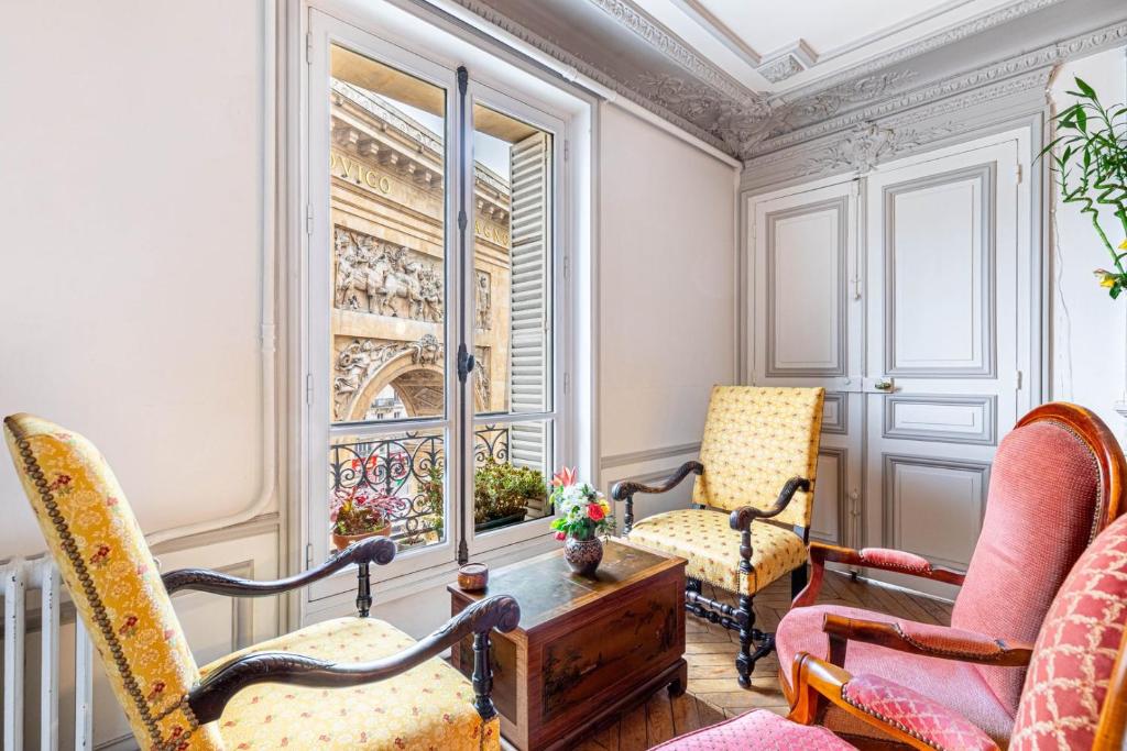 une chambre avec deux chaises, une table et une fenêtre dans l'établissement GuestReady - Charming Vintage with Iconic Views, à Paris