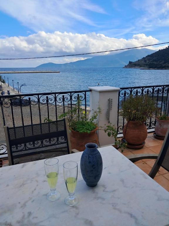 a table with two wine glasses and a vase on it at Agia Effimia RIVIERA APPARTMENT in Agia Effimia