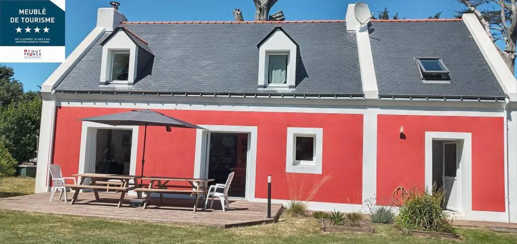 Maison rouge et blanche avec une table et des chaises dans l'établissement Location Maison Belle Ile en Mer 10 personnes, au Palais