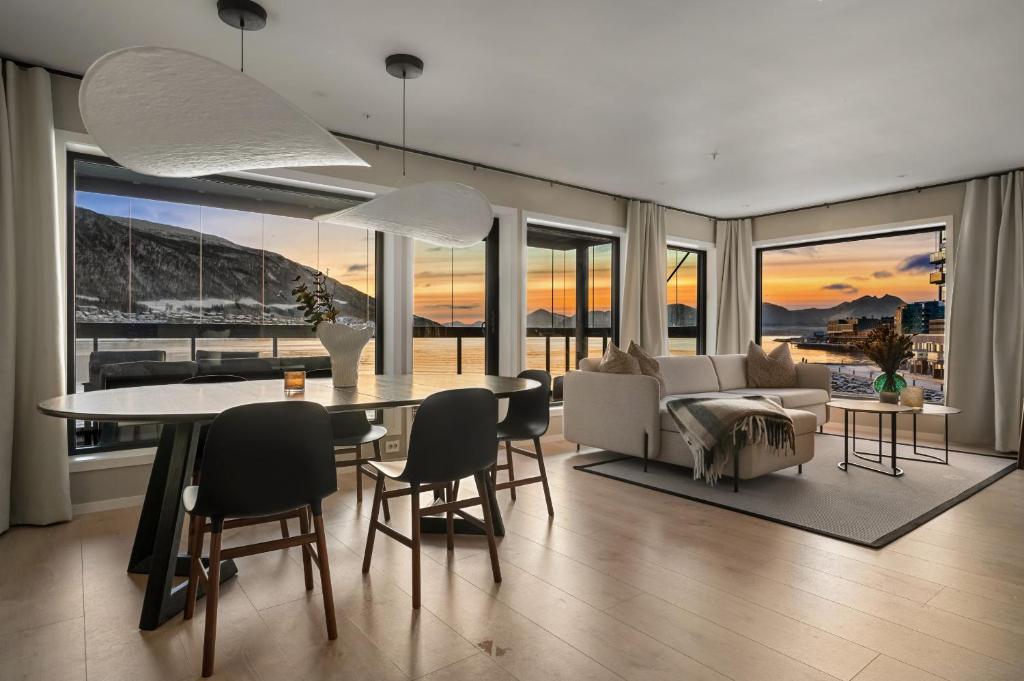 a living room with a table and chairs and a couch at Premium Penthouse Sea & Mountain view Apartments in Tromsø in Tromsø
